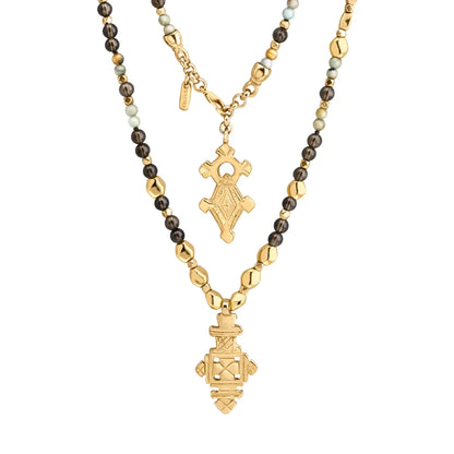 Collar de 112cm en baño de oro 22K, con una composición de piedras de 6mm y cuentas doradas, complementando un dije de cruz africana barroca - Joyería y bisutería fina