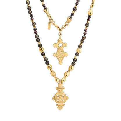 Collar de 112cm en baño de oro 22K, con una composición de piedras de 6mm y cuentas doradas, complementando un dije de cruz africana barroca - Joyería y bisutería fina