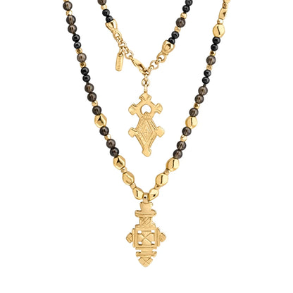 Collar de 112cm en baño de oro 22K, con una composición de piedras de 6mm y cuentas doradas, complementando un dije de cruz africana barroca - Joyería y bisutería fina