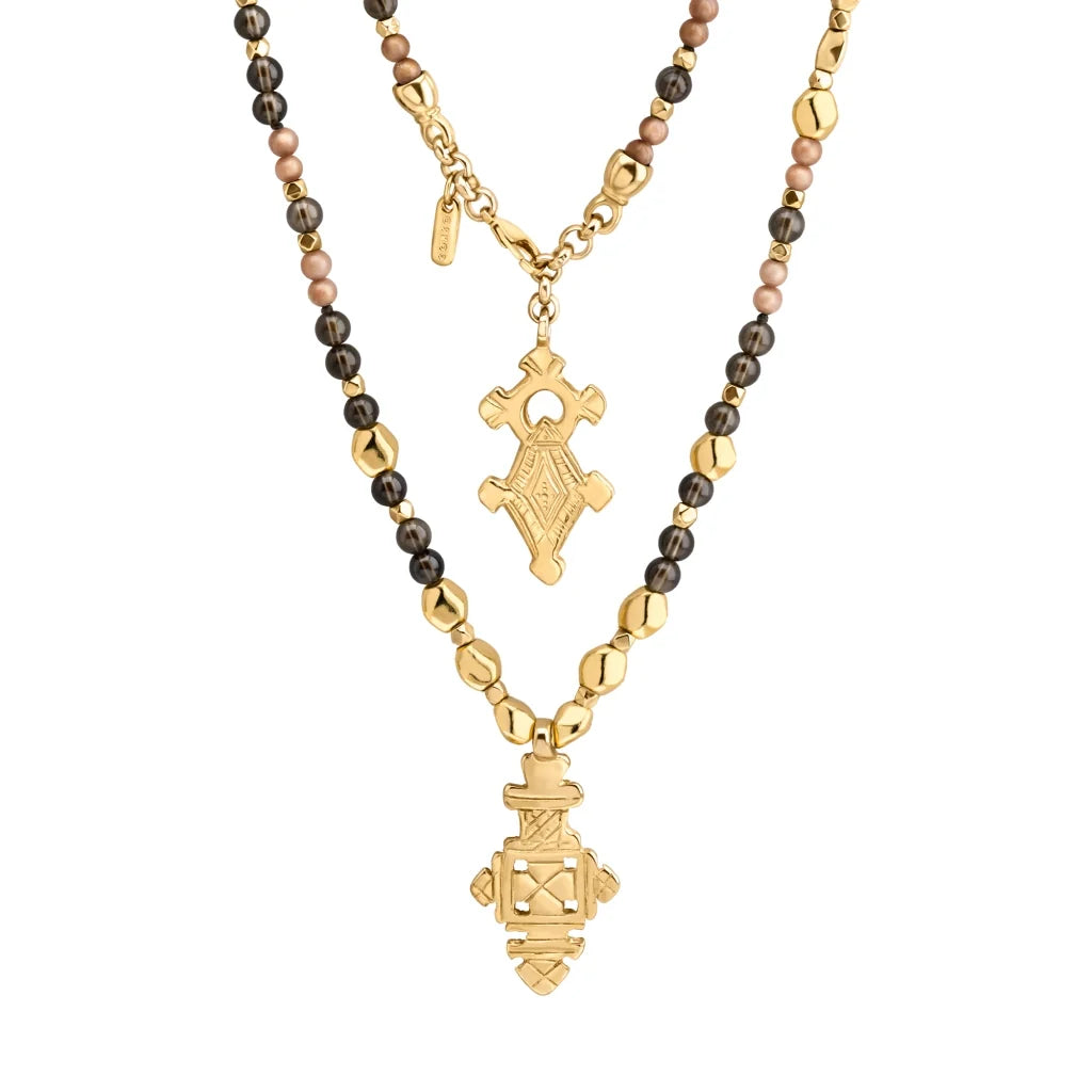 Collar de 112cm en baño de oro 22K, con una composición de piedras de 6mm y cuentas doradas, complementando un dije de cruz africana barroca - Joyería y bisutería fina