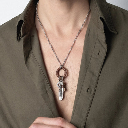 Collar para hombre con cadena de acero anticado, aro con piel tejida y dije de pluma. Corso Joyería - Joyería y bisutería fina