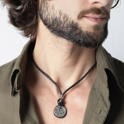 Collar para hombre de piel trenzada con dije de moneda tibetana en acero pulido. Corso Joyería - Joyería y bisutería fina