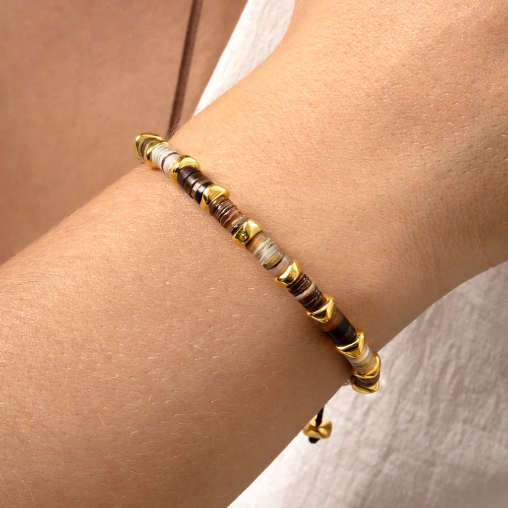 Pulsera ajustable con hilo de seda, conchas filipinas de distintos tonos, con placa con insignia Corso y semillas en baño de oro de 22K - Joyería y bisutería fina