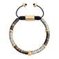 Pulsera ajustable con conchas filipinas en distintos tonos, con placa insignia, semillas y mantra en baño de oro 22K