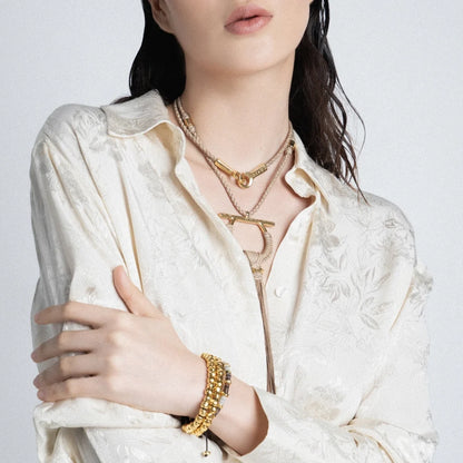 Pulsera de piel natural de borrego trenzada, con broche y cuentas geométricas en baño de oro de 22K - Joyería y bisutería fina